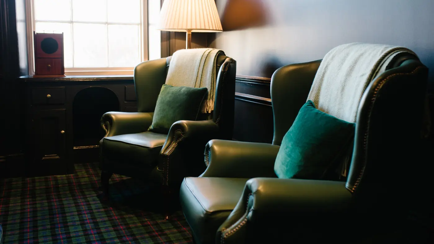 Two wing chairs by the window, with throws and velvet cushions